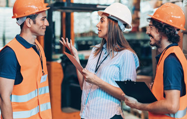 People in hardhats and hi-vis talking