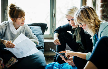 Team discussing plans around a tablet