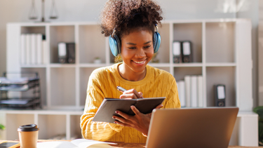 Woman taking notes on Adaptability as a KPI  from a laptop screen