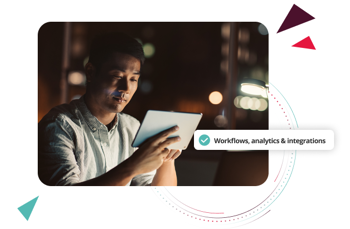 Person using a tablet at a desk in a dimly lit workspace, reviewing HR software workflows, analytics, and integrations to streamline operations.