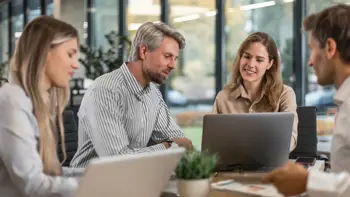 Team working on laptops managing Tupe transfers