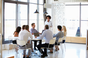 Diverse business team in a modern office discussing payroll solutions, representing key features of top payroll software